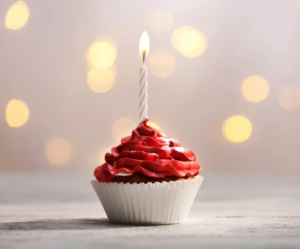 Deliciosos cupcakes de aniversário na mesa no fundo claro — Fotografia de Stock