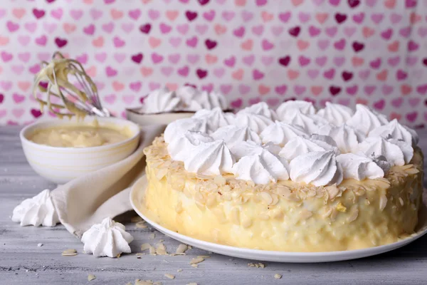 Kue meringue buatan sendiri yang lezat di atas meja kayu, di latar belakang merah muda — Stok Foto