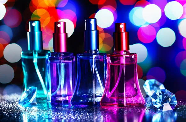 Kadın parfüm şenlikli parlak zemin üzerine güzel şişelerde — Stok fotoğraf