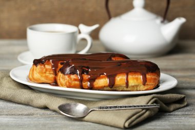 Lezzetli eklerleri ve ahşap masa üzerinde çay