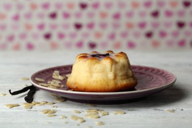 Renk arka plan üzerinde ahşap masa üzerinde lezzetli peynirli kek