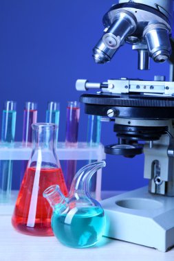 Mikroskop ve masaya renk arka plan üzerinde test tüpleri