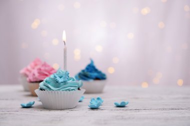 Lezzetli doğum günü kek ışık arka plan üzerinde masada