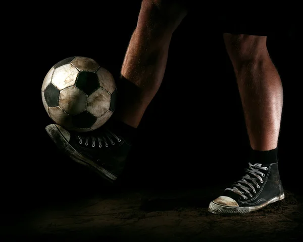 Bola de futebol no chão no fundo escuro — Fotografia de Stock