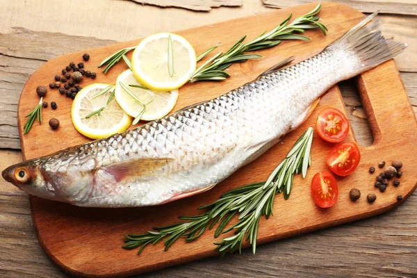 Verse rauwe vis en voedselingrediënten op tafel — Stockfoto