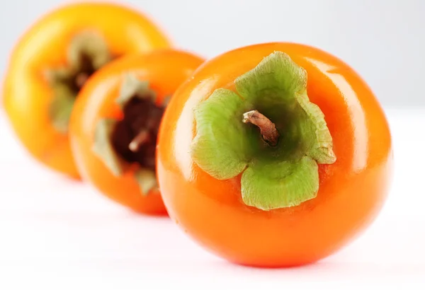 Persimmon matang pada warna latar belakang kayu — Stok Foto