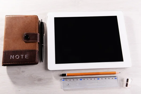 Tablet Pc met notitieblok op houten tafel achtergrond — Stockfoto