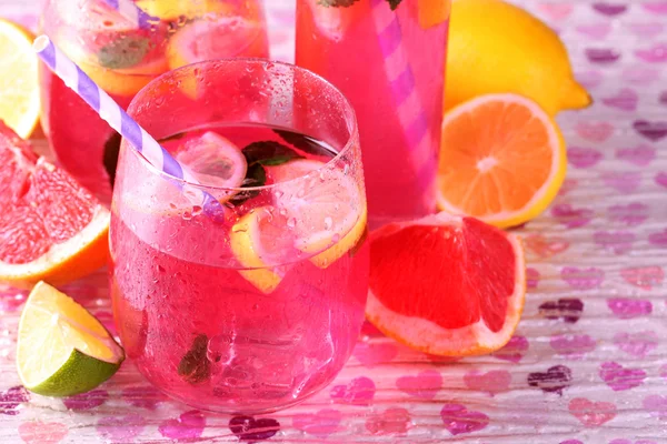 Ροζ λεμονάδα σε γυαλιά και μπουκάλι σε φωτεινό φόντο — Φωτογραφία Αρχείου