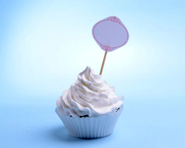 Delicious cupcake with inscription on table on blue background — Stock Photo, Image