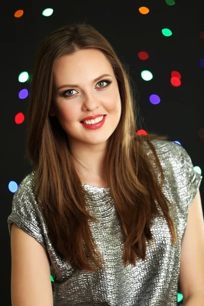 Smiling girl on multicolor lights background — Stock Photo, Image