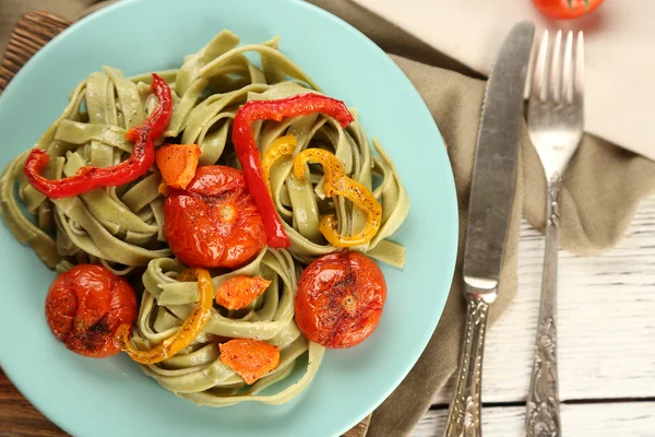 Leckere Pasta mit Paprika, Karotten und Tomaten auf Holztischhintergrund — Stockfoto