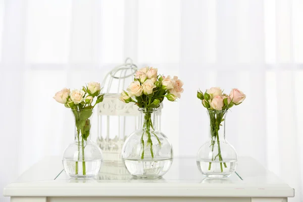 Beautiful bouquet of flowers in vases on window background Stock Picture