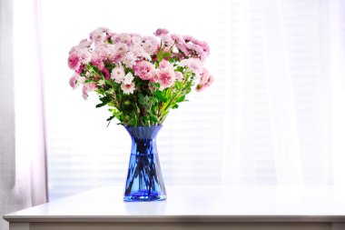 Vazodaki güzel çiçekler Pencereden gelen ışıkla