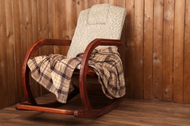 Sallanan sandalye ahşap duvar arka plan üzerinde ekose kaplı