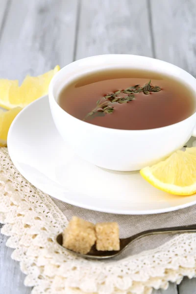 Chutné bylinné čaje s tymiánem a citronem na dřevěný stůl — Stock fotografie