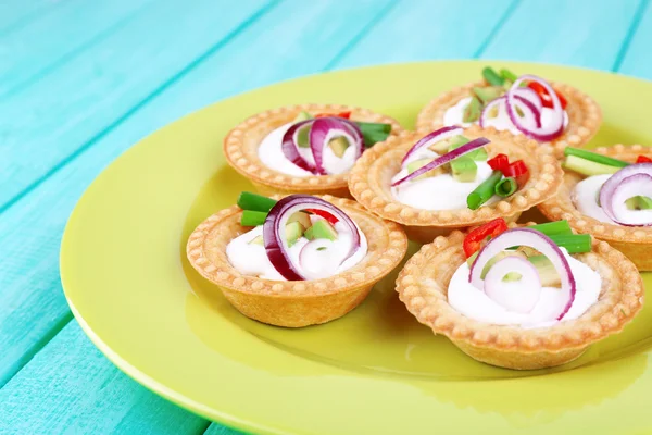 Tartlets med grönsaker och grönsaker med sås på tallriken på bordet — Stockfoto