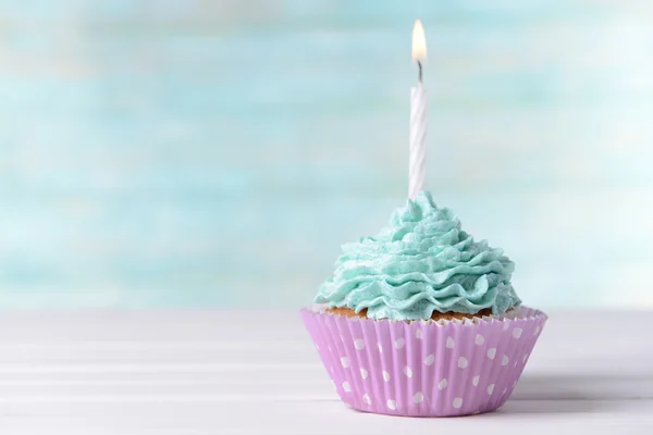 Delicious birthday cupcake on table on light blue background — Stock Photo, Image