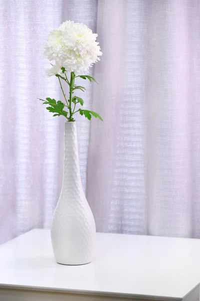 Beautiful flowers in vase on curtains background — Stock Photo, Image