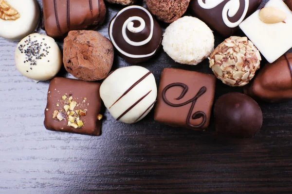 Assorted Chocolade op de donkere houten glad achtergrond — Stockfoto