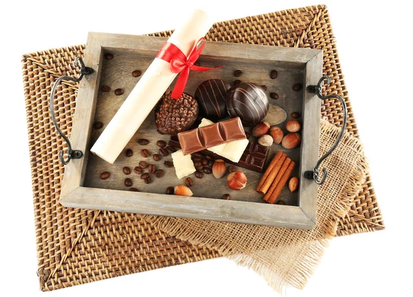 Sweets with rolled paper on wooden stand and wicker mat isolated on white — Stock Photo, Image