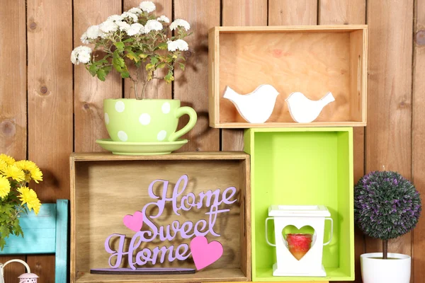 Beautiful colorful shelves with different home related objects on wooden wall background