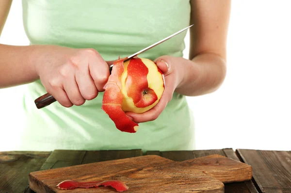 Femme mains pelées pomme avec couteau sur table en bois, isolé sur fond blanc — Photo