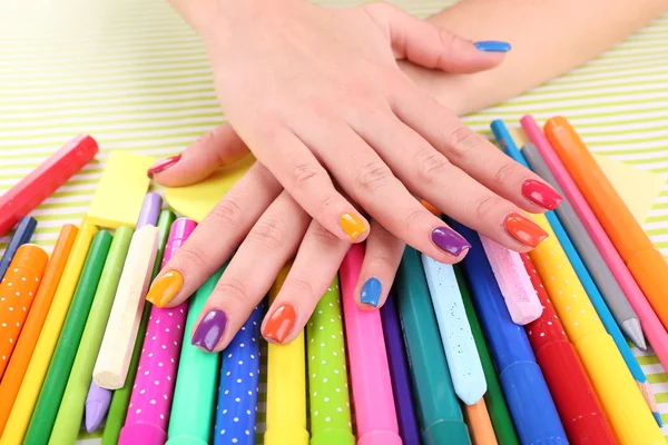 Багатобарвний жіночий манікюр з маркерами та олівцями на яскравому фоні — стокове фото