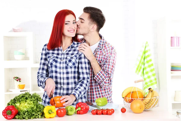 幸せなカップルは、台所で野菜を切る — ストック写真