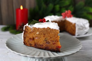 Pasta dilimi krem masada ahşap duvar arka plan üzerinde Noel dekorasyonu ile kaplı