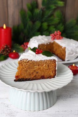 Pasta dilimi krem masada ahşap duvar arka plan üzerinde Noel dekorasyonu ile kaplı