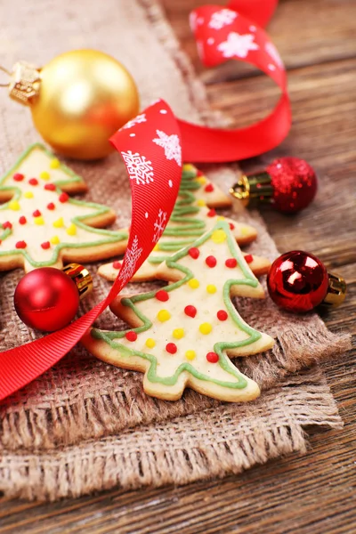 黄麻布や木製のテーブル背景にクリスマスの装飾とジンジャーブレッド クッキー — ストック写真