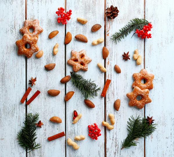 Galletas con nueces y ramitas de árbol de Navidad sobre fondo de madera de color — Foto de Stock