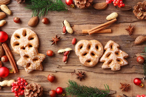 Galletas con frutos secos, especias y ramitas de árbol de Navidad sobre fondo rústico de madera — Foto de Stock