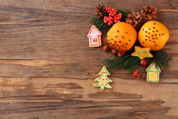 Laranja com biscoitos, especiarias e raminhos de árvore de Natal em fundo de madeira rústica — Fotografia de Stock