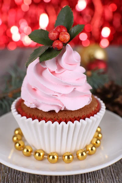 Tasse-Kuchen mit Sahne auf Untertasse und Weihnachtsdekoration auf Holztisch und leuchten hell Hintergrund — Stockfoto