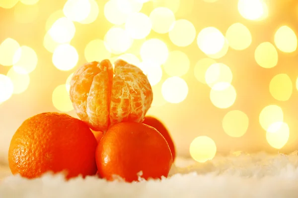 Färsk mogen mandariner på snö, på ljus bakgrund — Stockfoto