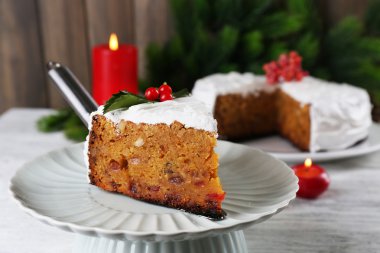 Pasta dilimi krem masada ahşap duvar arka plan üzerinde Noel dekorasyonu ile kaplı