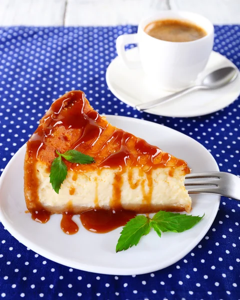 Gâteau au fromage et tasse de café sur nappe à pois — Photo