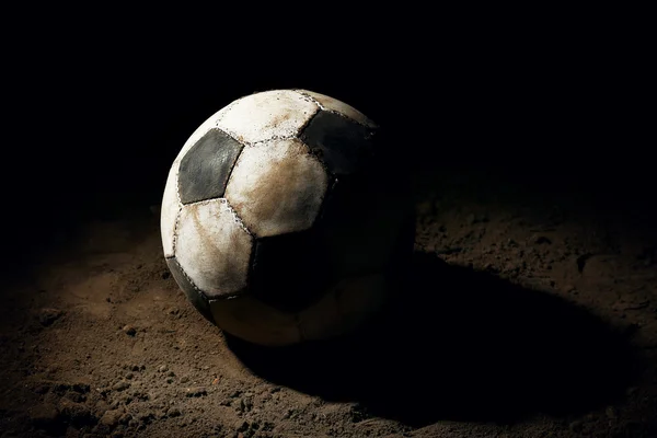 Fotbalový míč na zem na tmavém pozadí — Stock fotografie