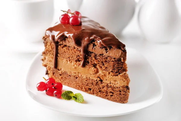 Delicious chocolate cake on plate on table on light background — Stok Foto