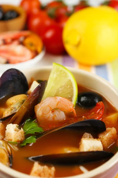 Смачний суп з креветками, мідіями, помідорами та чорними оливками в мисці на дерев'яному фоні — стокове фото