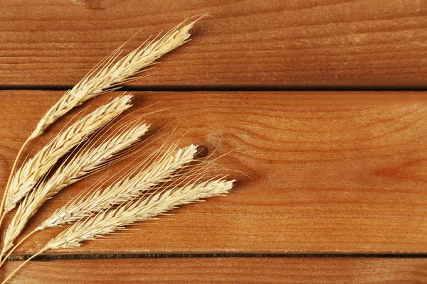 Espiguillas de trigo sobre fondo de madera — Foto de Stock