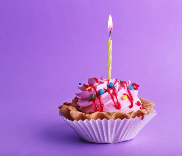 Kuchen mit Geburtstagskerze auf lila Hintergrund — Stockfoto