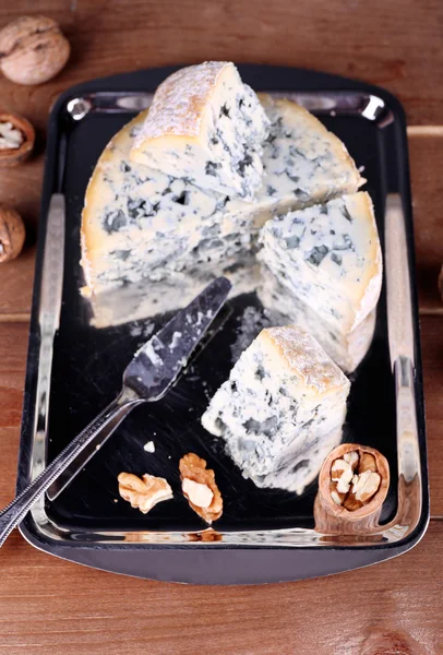 Queso azul con nueces y hoja en bandeja de metal y fondo de mesa de madera —  Fotos de Stock