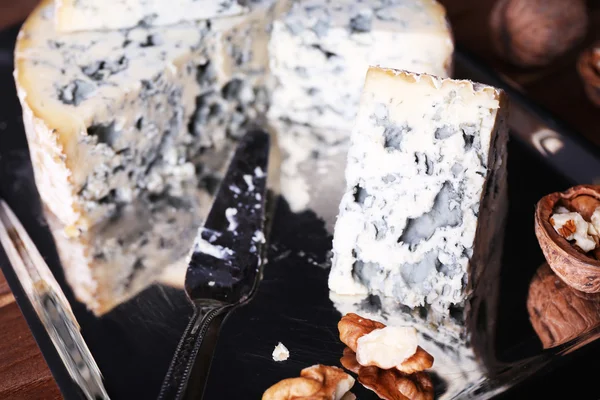 Μπλε τυρί με ξηρούς καρπούς και λεπίδα στο μεταλλικό δίσκο και ξύλινο τραπέζι φόντο — Φωτογραφία Αρχείου