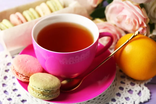 Färgglada macaroons med kopp te på trä bakgrund — Stockfoto