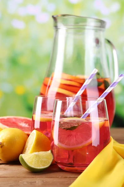 Gözlük ve sürahi doğal zemin üzerine masada pembe limonata — Stok fotoğraf