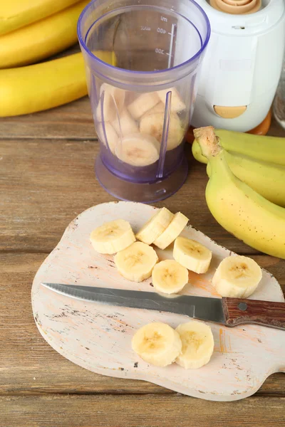 Sliced banana on cutting board, on wooden background — Stock Photo, Image