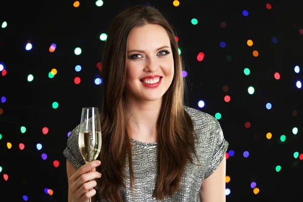 Chica sonriente con copa de vino sobre fondo de luces — Foto de Stock