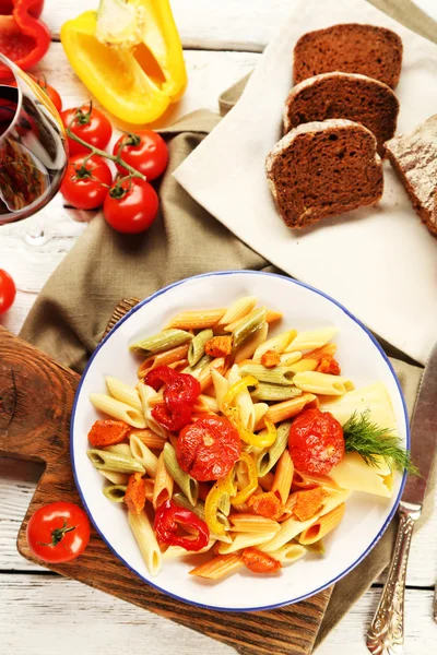 Pastasalade met peper, wortel en tomaten op houten tafel achtergrond — Stockfoto